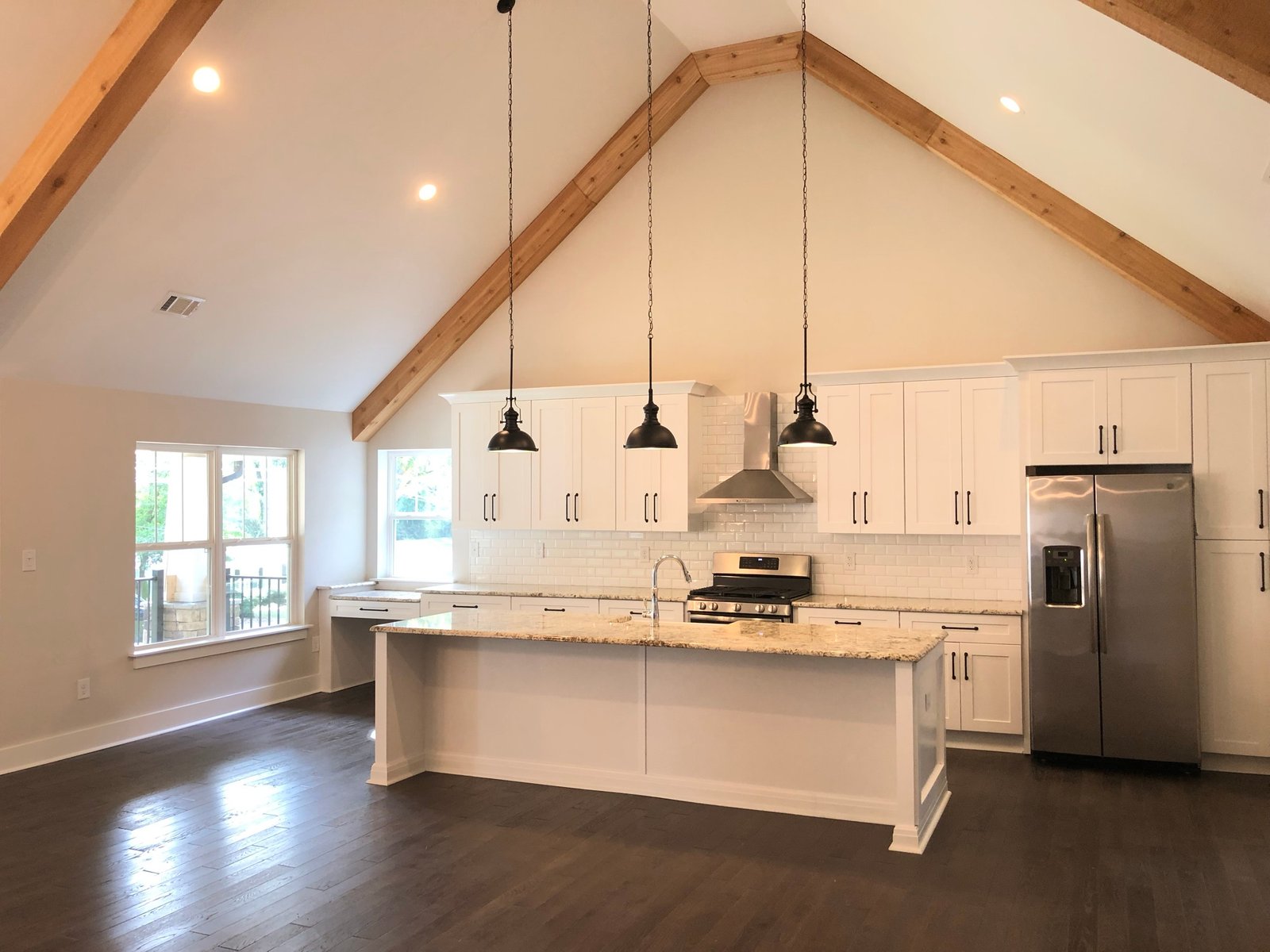 Vaulted kitchen with exposed timber beams in a permitted home addition in Cumming, GA